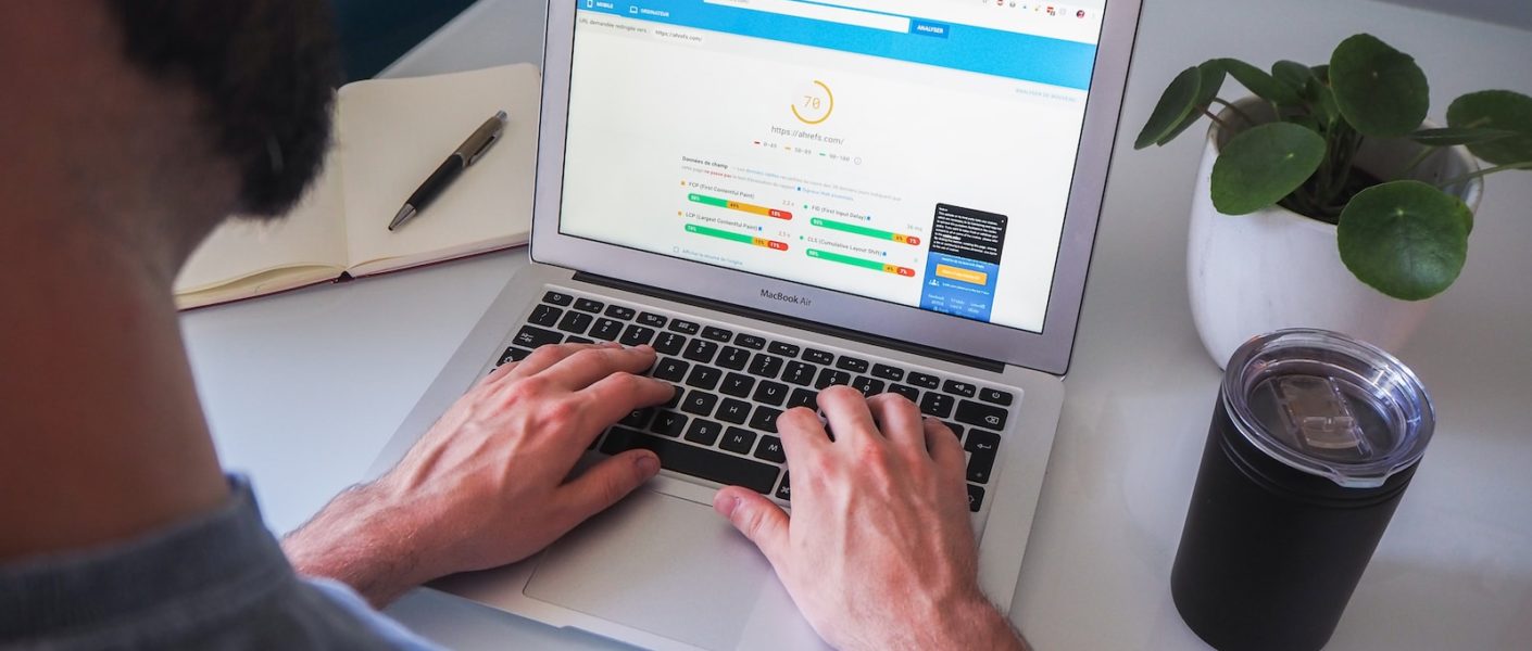 person using macbook pro on white table